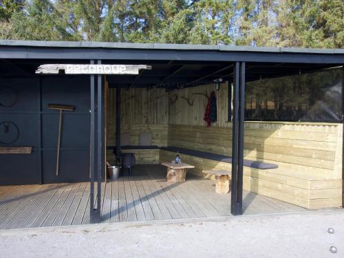 a wooden shelter with a bench and a table at Carsaig in Port of Menteith