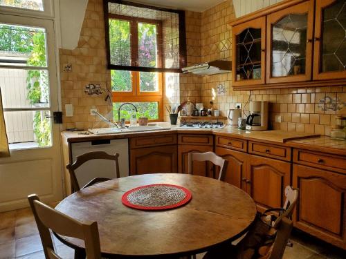 a kitchen with a wooden table and a table and chairs at Maison Charlotte in Montcuq