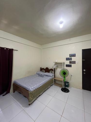 a bedroom with a bed and a green fan at Transient St Jude Apartments San Jose Occidental Mindoro in San Jose