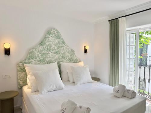 a bedroom with a white bed with a large window at La Clé Boutique Hotel Old Town Marbella in Marbella