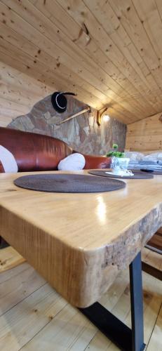 a wooden table in a room with a stone wall at Babiogórskie Domki in Lipnica Wielka