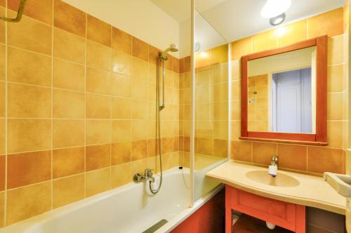 une salle de bain avec une baignoire, un lavabo et un miroir dans l'établissement La résidence du Lac - maeva Home - Appartement 2 pièces 4 personnes - Sélection MAE-7331, à Monflanquin