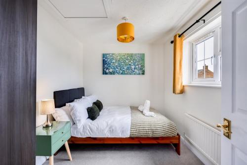 a bedroom with a bed and a window at Winslow House - Walking Distance to the High Street - Driveway Parking, Fast WiFi, Smart TV and Self-Check-In by Yoko Property in Buckingham