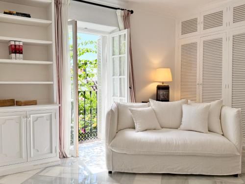 a white couch in a living room with a window at La Clé Boutique Hotel Old Town Marbella in Marbella