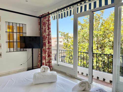 a bedroom with a bed and a large window at La Clé Boutique Hotel Old Town Marbella in Marbella