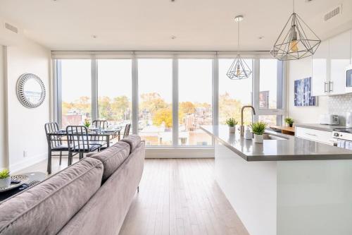 a kitchen and living room with a couch and a table at Contemporary 3BR with Natural Light High Park North Nearest Intersection - Dorval Rd, in Toronto