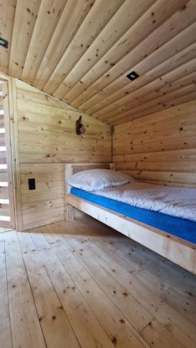 a log cabin with a bed in a room at Babiogórskie Domki in Lipnica Wielka