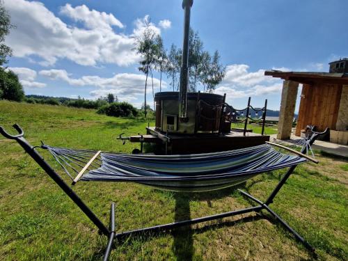 a hammock sitting in a field in a field at Babiogórskie Domki in Lipnica Wielka