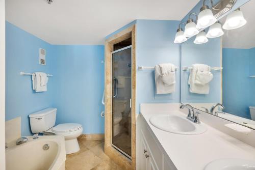 Un baño azul con inodoro y lavabo. en Beach Club #209, en Saint Simons Island