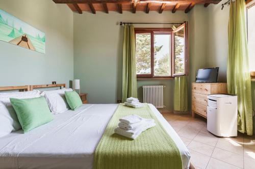 a bedroom with a large bed and a window at Masseria Le Querciole in Fauglia