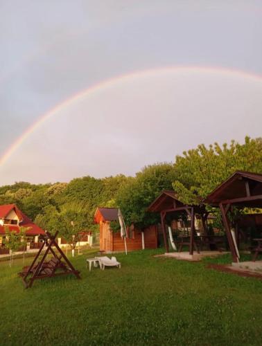 a rainbow in the sky over a park with a playground at Vila Costea in Geoagiu Băi