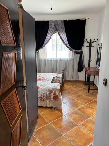 a bedroom with a bed and a window at Les dunes de martil familles in Martil