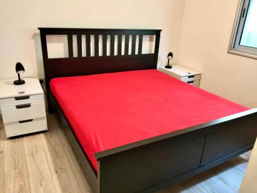a bedroom with a large red bed with two night stands at Regina by the Sea in Limassol