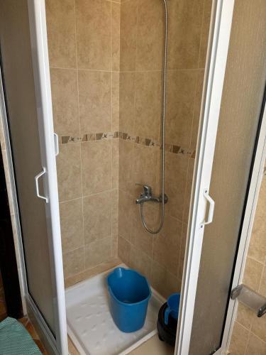 a shower with a blue bucket in a bathroom at Les dunes de martil familles in Martil