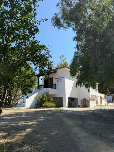 a white building with a balcony on the side of it at Ammouliani Beach House in Ammouliani