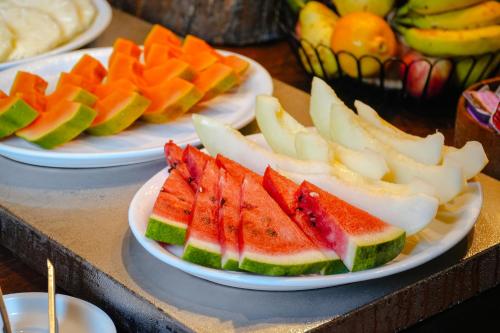 three plates of fruit on a table with plates of food at VELINN Pousada Bromelias in Ilhabela