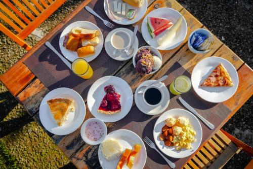a wooden table with plates of food on it at VELINN Pousada Bromelias in Ilhabela