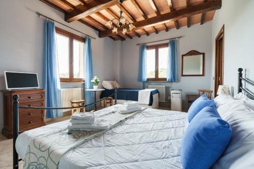 a bedroom with a large bed and a tv at Masseria Le Querciole in Fauglia