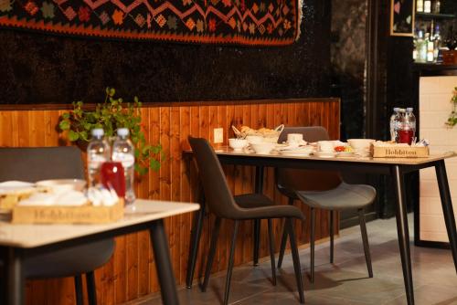a dining room with two tables and chairs with food at Hotel Hobbiton near Vardzia Caves in T'mogvi