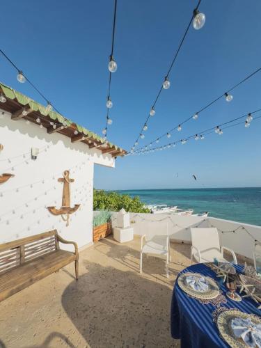 a patio with a table and chairs and the ocean at Posada La Gotera in El Roque