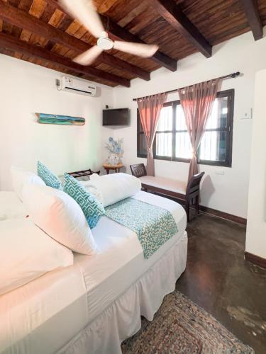a bedroom with a bed and a couch and windows at Posada La Gotera in El Roque
