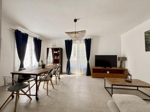 a living room with a table and a tv at Appartement cosy Aigues-Mortes centre 4 pers in Aigues-Mortes