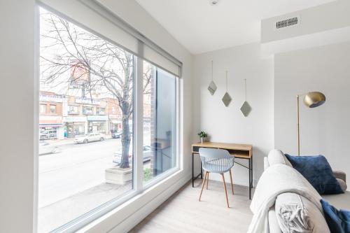 a living room with a large window and a desk at Stylish 3BR Condo near High Park Trails Nearest Intersection Dundas St W in Toronto
