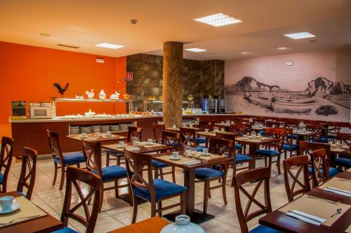 um restaurante com mesas e cadeiras de madeira e um bar em Petit Palau - Adults Only em Blanes