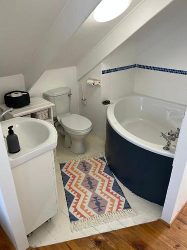 a bathroom with a tub and a toilet and a sink at Huisie by die See in Stilbaai