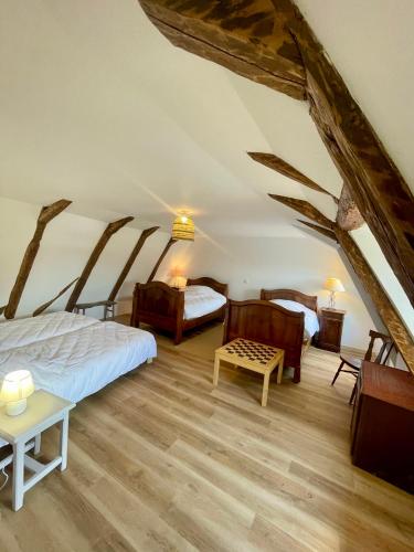 - une chambre mansardée avec 2 lits et une table dans l'établissement Maison de caractère rénovée avec terrain de pétanque, à Saint-Cirgues-de-Jordanne