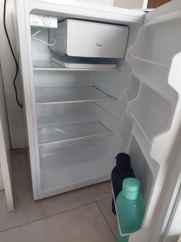 an open refrigerator with a water bottle in it at Flat Boa Viagem -500 m praia - Golden Style in Recife