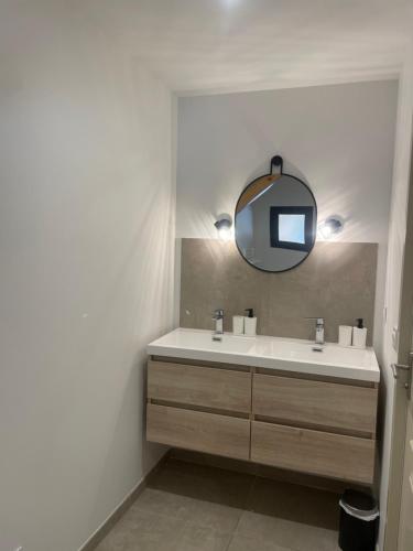 une salle de bain avec un lavabo et un miroir dans l'établissement Maison de caractère rénovée avec terrain de pétanque, à Saint-Cirgues-de-Jordanne