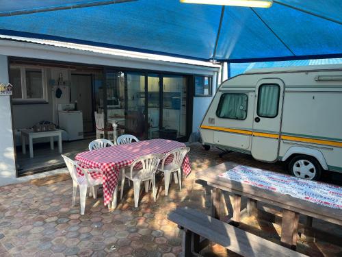 a table and chairs and a table and a van at Huisie by die See in Stilbaai