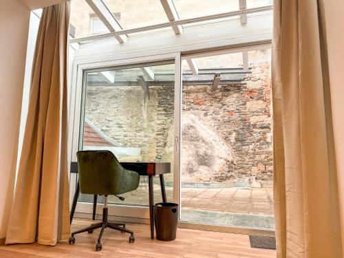 a room with a window with a chair and a desk at Danube Holiday Rooms in Krems an der Donau