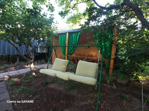 a couple of chairs sitting under a tree at Green World in Byurakan