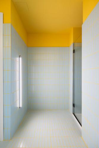 an empty bathroom with blue and yellow walls and a door at In Piazza BnB in San Salvo