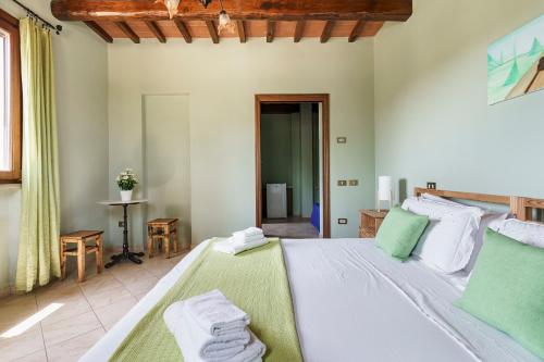 a bedroom with a large bed with towels on it at Masseria Le Querciole in Fauglia