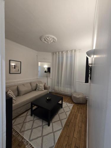 a living room with a couch and a coffee table at Appartement cosy aux portes de Paris in Bois-Colombes