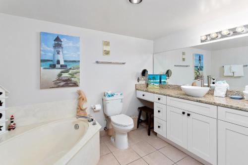 a bathroom with a tub and a toilet and a sink at Beach Club #224 in Saint Simons Island