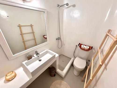 a bathroom with a sink and a toilet and a mirror at Akra in Houlakia