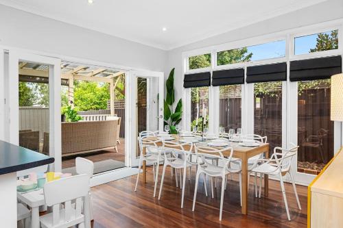 a dining room with a table and white chairs at Classic Australian Charm in Perth