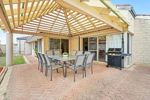 a patio with a table and chairs and a grill at The Grand Family Mansion 5BR with Pool Table, BBQ in Perth