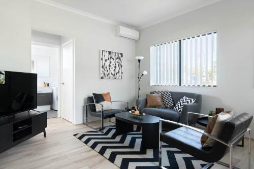 a living room with a couch and a table at Chic Exec 2bdr 2bath -River,FREO,Parking,AC in Perth