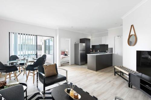 a living room with a table and chairs and a kitchen at Chic Exec 2bdr 2bath -River,FREO,Parking,AC in Perth