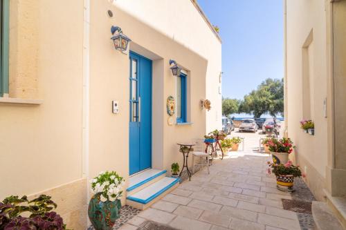 a blue door on the side of a building with plants at Tumy's Room in Marzamemi