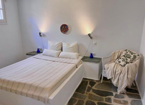 a small bedroom with a bed and a chair at Akra in Houlakia