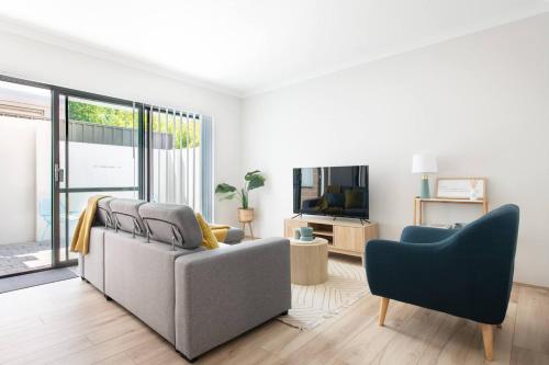 a living room with a couch and a chair at Bright Trendy 3BR Apt - Walk to River & Shops in Perth
