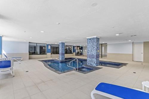 a large lobby with a pool and two columns at City Living Retreat - 2BR Apartment in East Perth in Perth