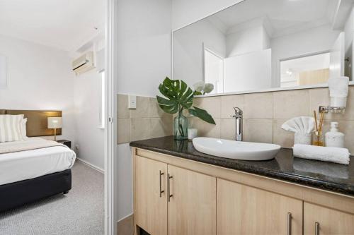a bathroom with a sink and a bed at East Perth Family Zen CATBus, CBD,ElizabethQuay in Perth