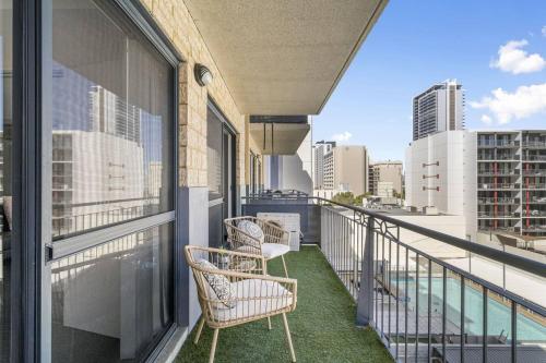 a balcony with chairs and a view of the city at City Living Retreat - 2BR Apartment in East Perth in Perth